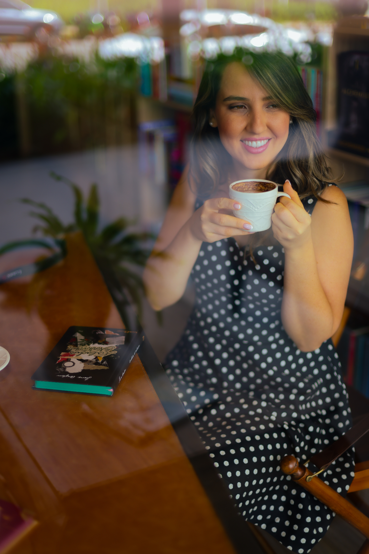 Xícara de café com latte art ao lado de um livro aberto